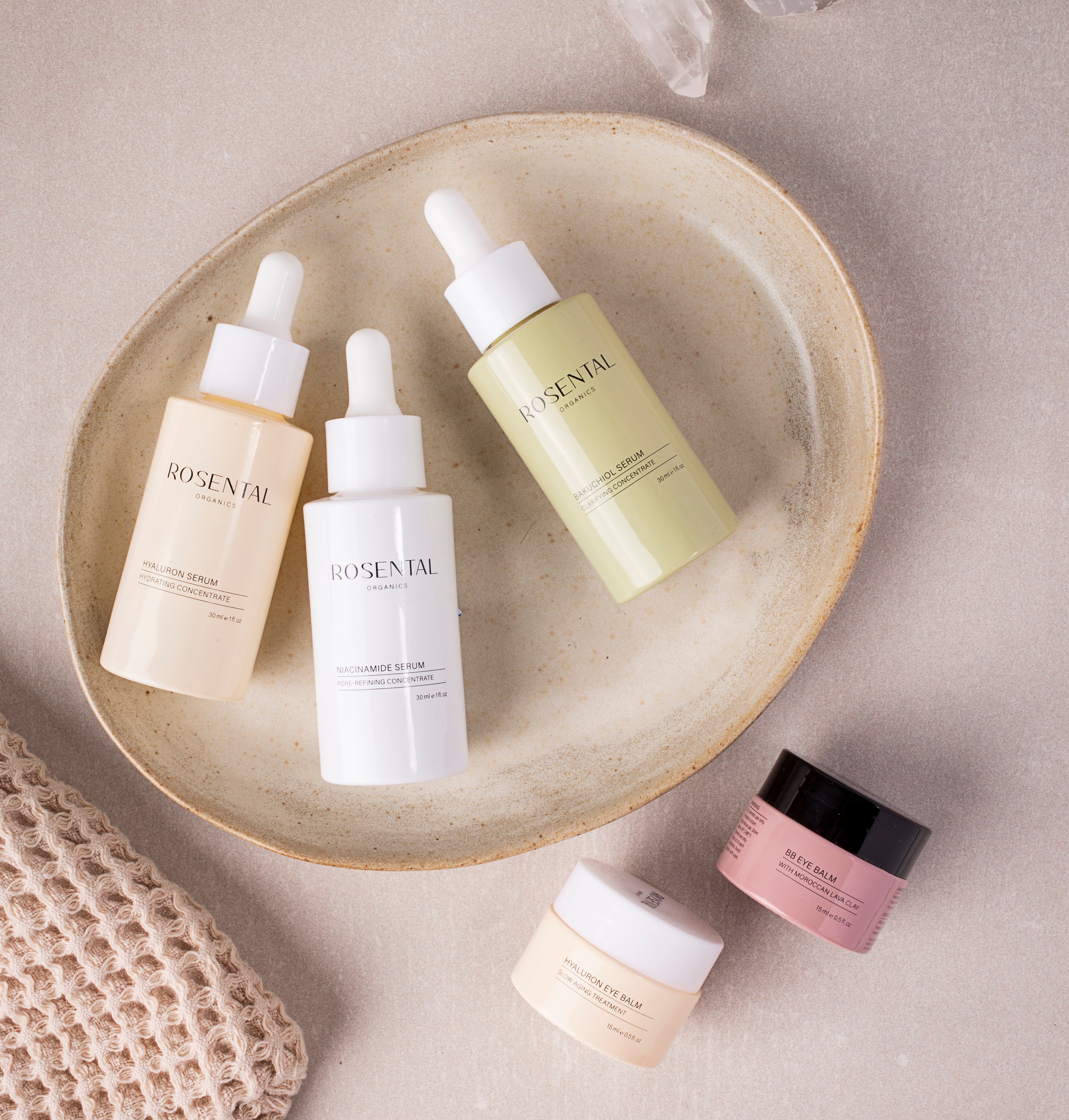 Bestseller producten van Rosental Organics liggen verspreid op beige marmer en een lichte ondergrond.