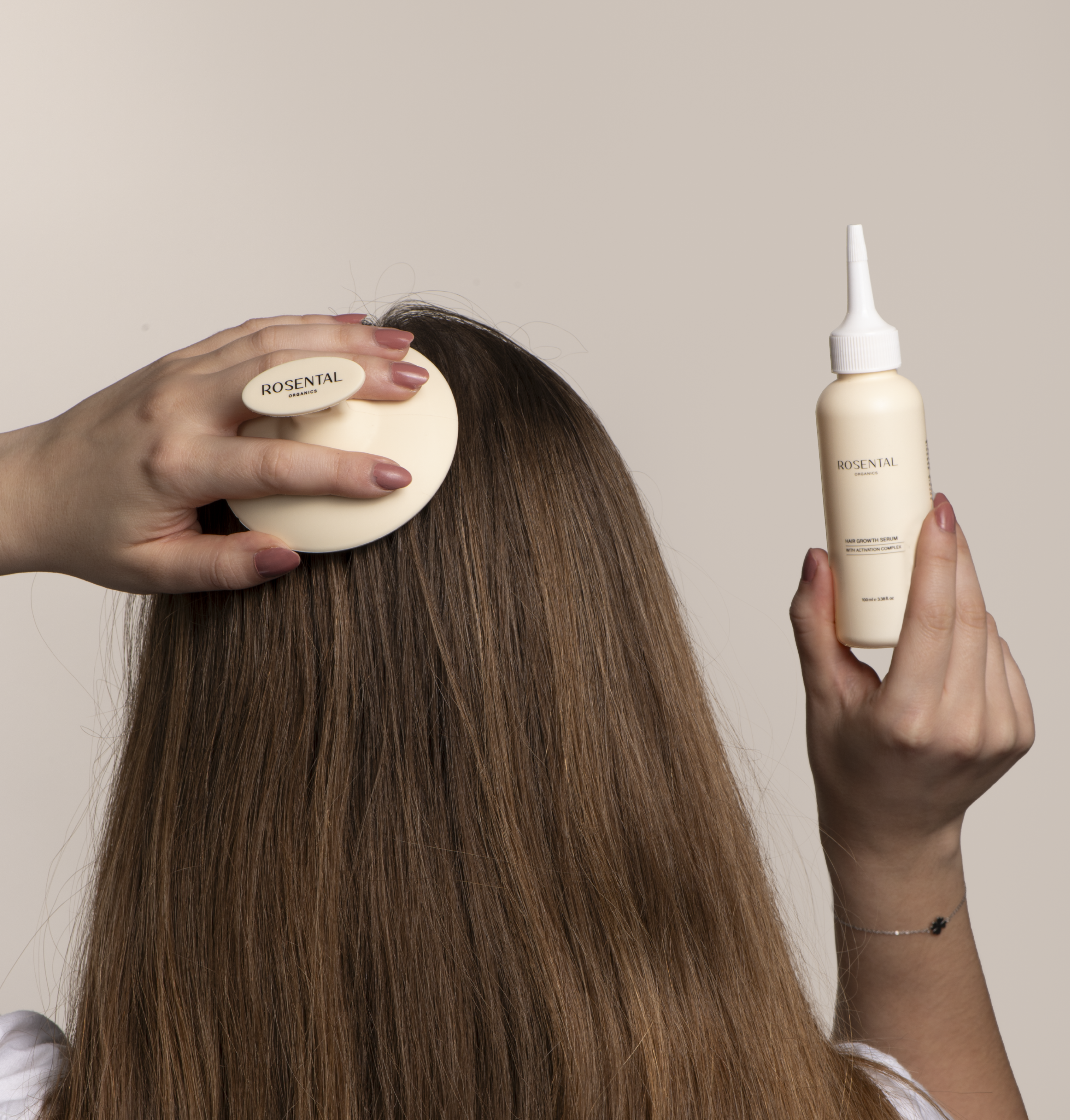 Persoon borstelt haar met Rosental-borstel en houdt een Rosental-productfles vast, neutrale achtergrond.